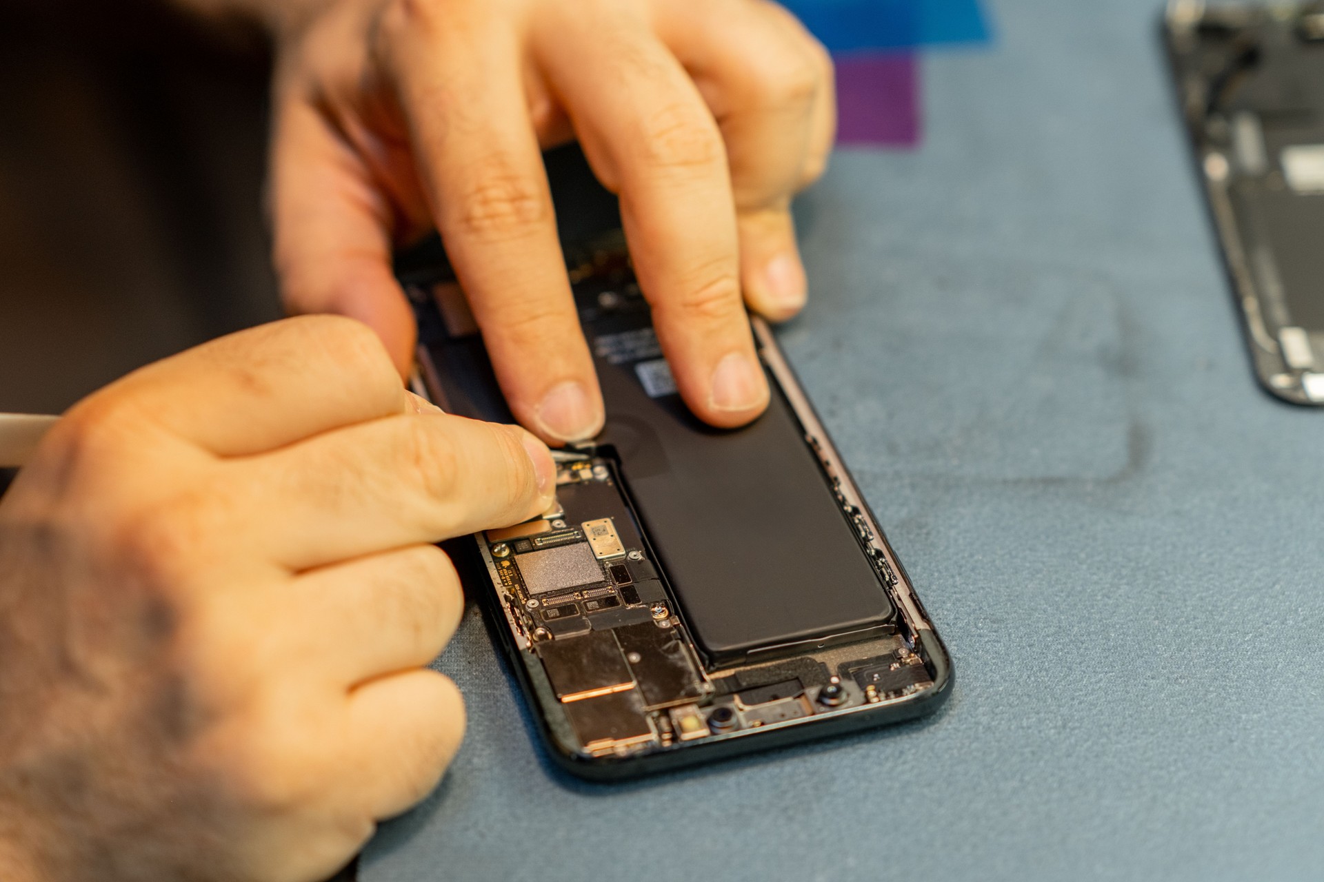 Phone Repair Technician Fixing a Smartphones Internal Components in a Workshop