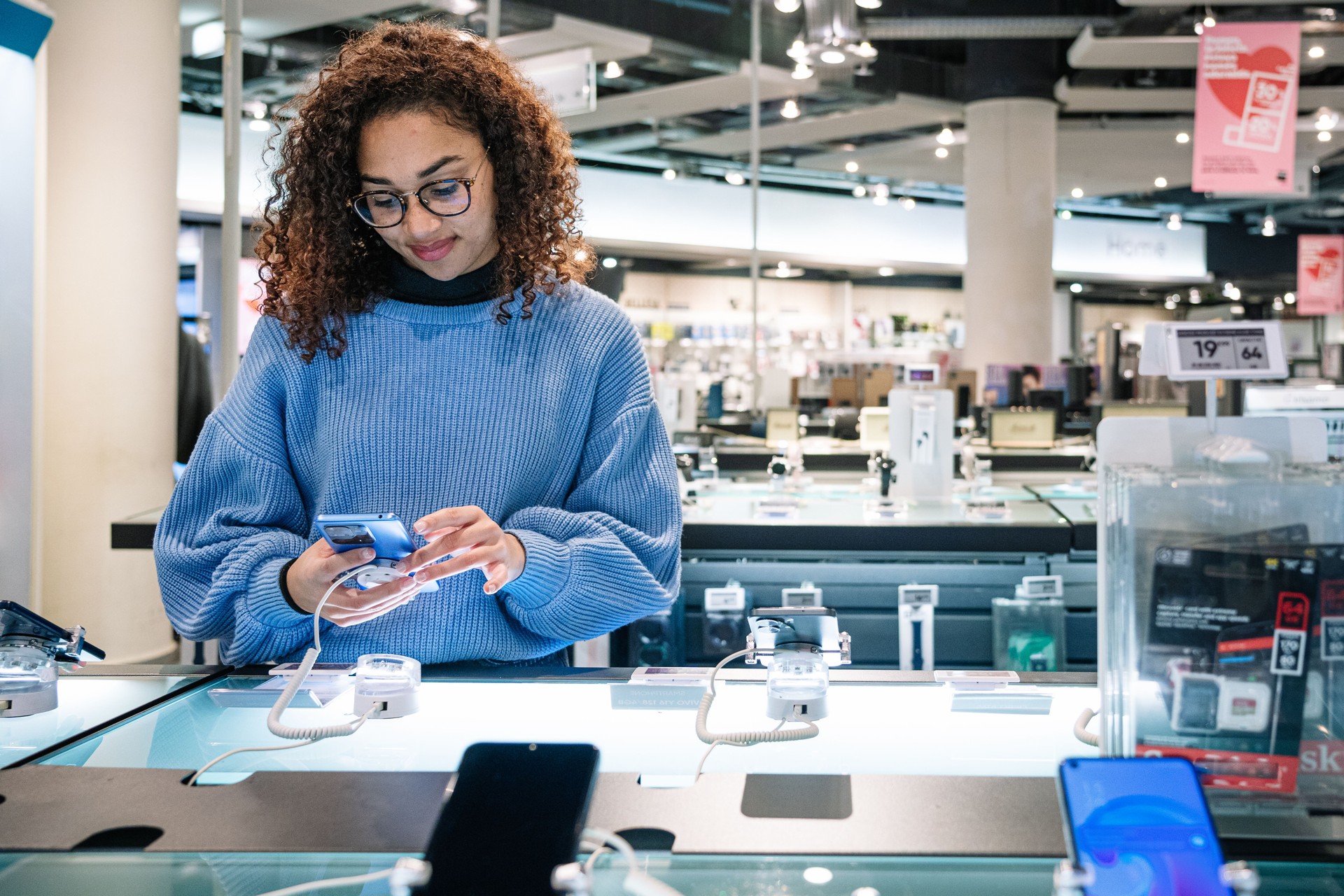 Black happy woman choosing smartphone in shop