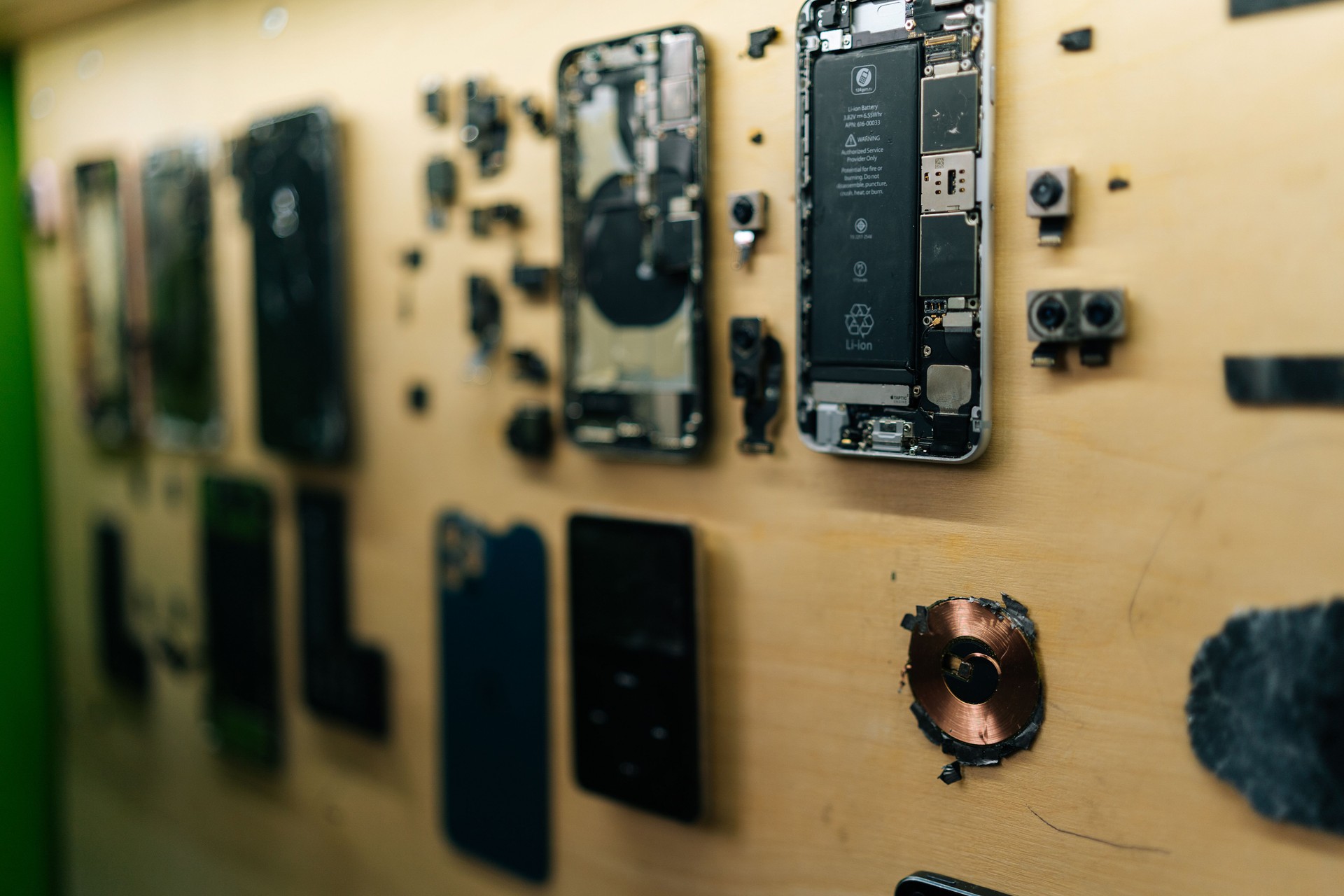 Close-up of several disassembled smartphones on wall, revealing intricate internal components for in-depth analysis and efficient repair